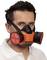 Un uomo indossa una maschera protettiva arancione e nera con filtri rotondi su entrambi i lati. Ha capelli scuri e corti.