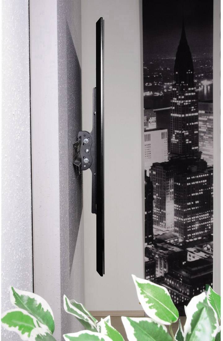 Un televisore piatto è montato a parete. Sullo sfondo c'è un'immagine in bianco e nero di una città con un grattacielo.