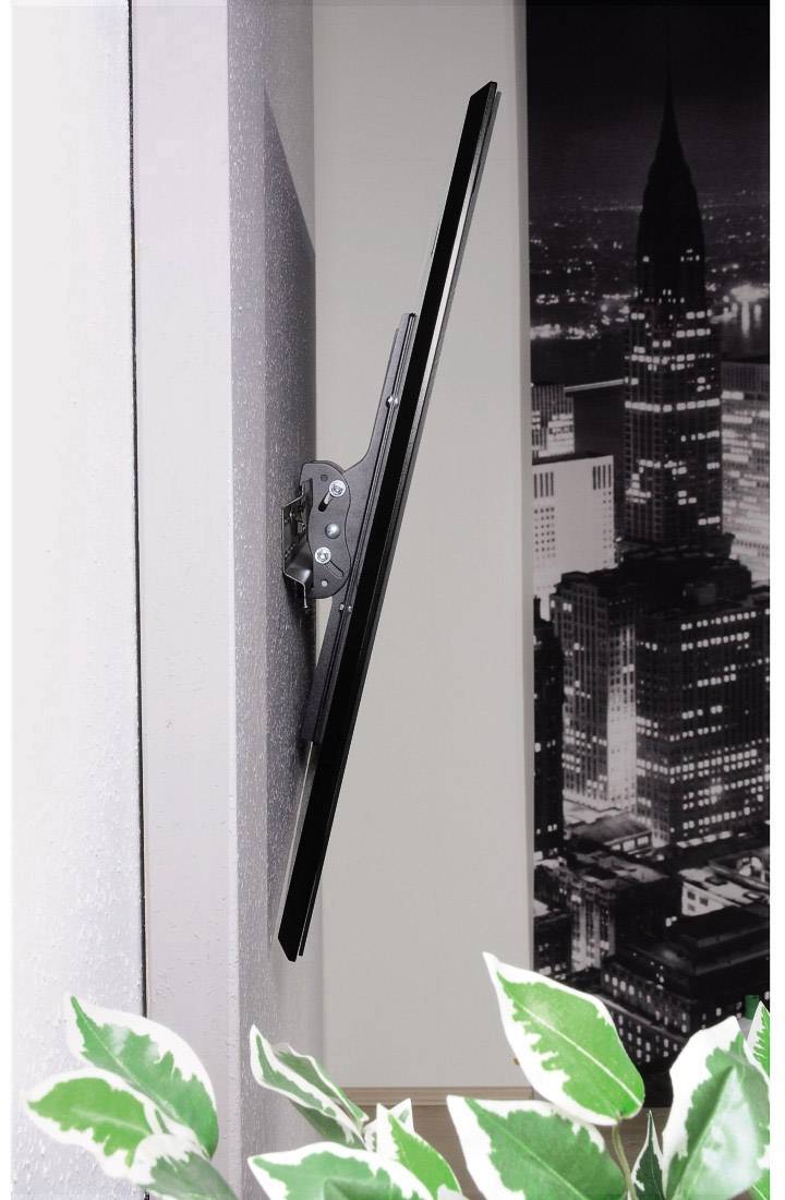 Un televisore a schermo piatto è montato lateralmente su una parete. Sullo sfondo è visibile un'immagine in bianco e nero di un paesaggio urbano.