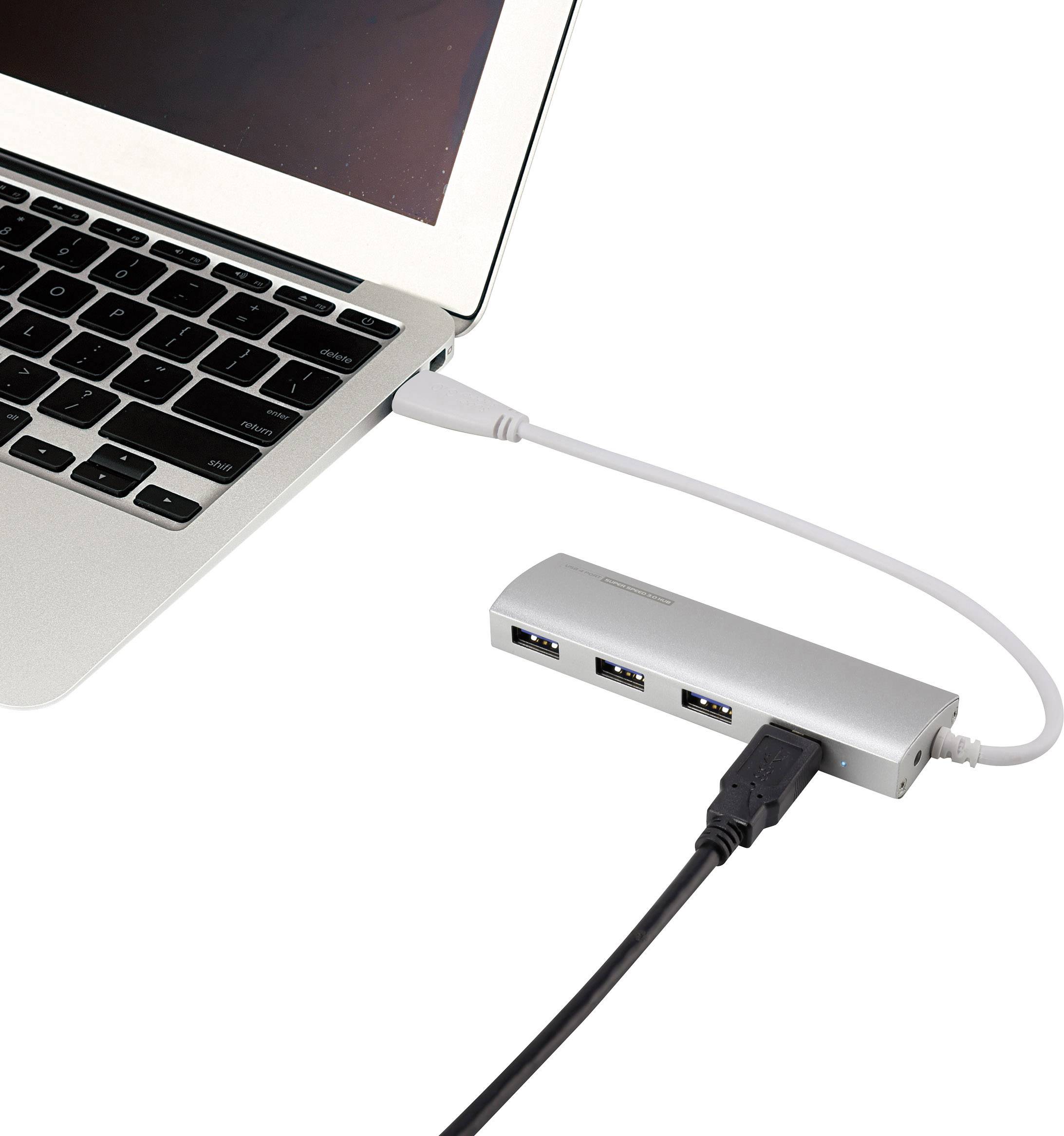 Un laptop argentato è collegato tramite un cavo USB a un hub USB argentato, al quale è collegato un altro cavo nero.