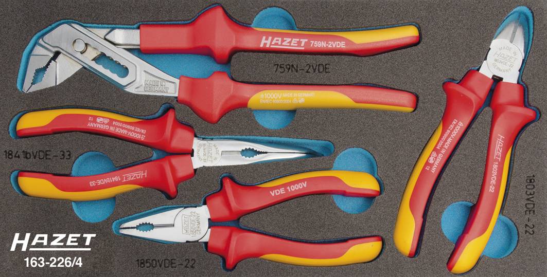 Un set di utensili composto da cinque pinze isolate con impugnature rosse e gialle, inserite in un supporto in schiuma nero, marca 'Hazet'.