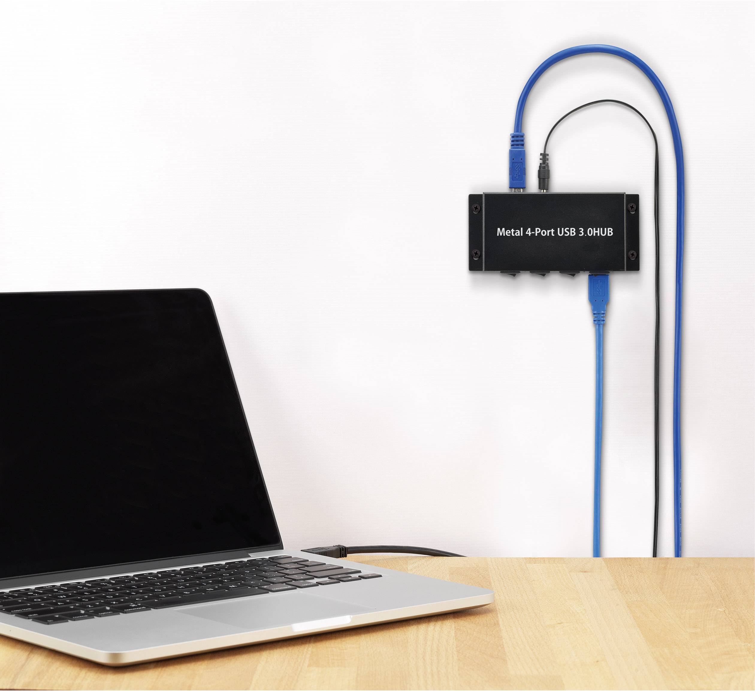 Un laptop è collegato tramite cavo a un hub USB nero fissato al muro. L'hub ha quattro porte.