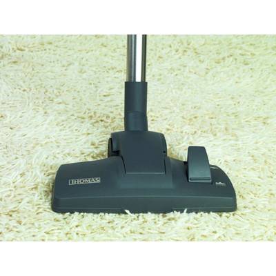 Un aspirapolvere con testa nera su un tappeto beige chiaro. La caratteristica principale è la facilità di utilizzo e la pulizia efficiente.