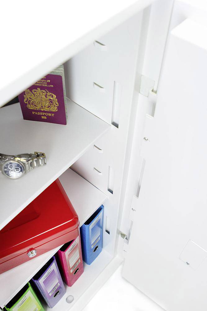 Armadio aperto con un passaporto britannico, un orologio da polso e raccoglitori di diversi colori.