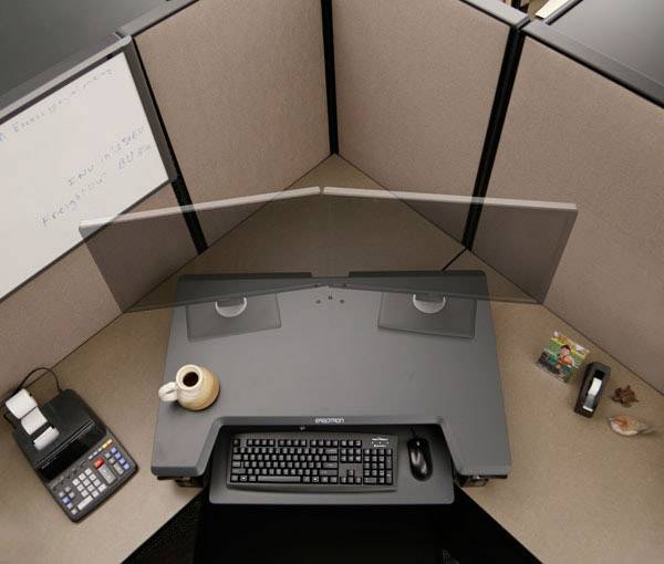 Postazione di lavoro in un ufficio con scrivania, computer, tastiera e telefono. Sono visibili una tazza di caffè e materiali da ufficio.