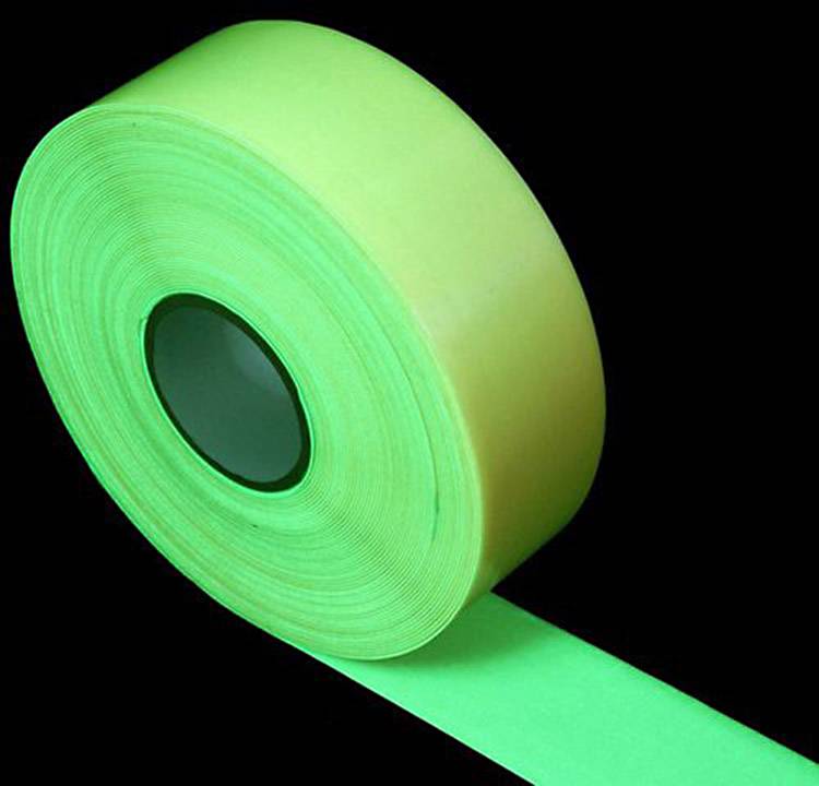 Un rotolo di nastro adesivo verde brillante su sfondo nero.