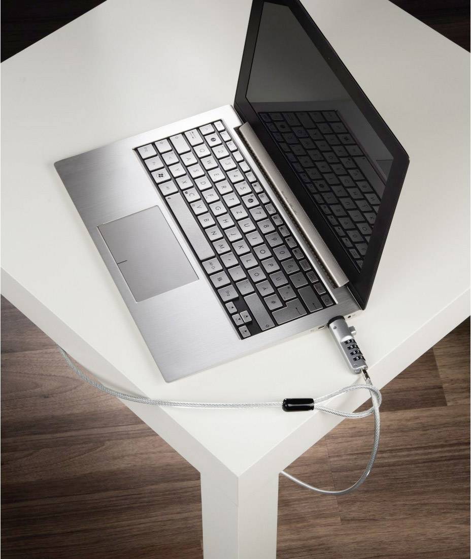 Un laptop su un tavolo è assicurato con un cavo di sicurezza fissato al bordo del tavolo.