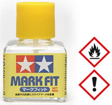 Bottiglia con tappo giallo e scritta 'MARK FIT'. Accanto due pittogrammi di pericolo: fiamma e punto esclamativo.