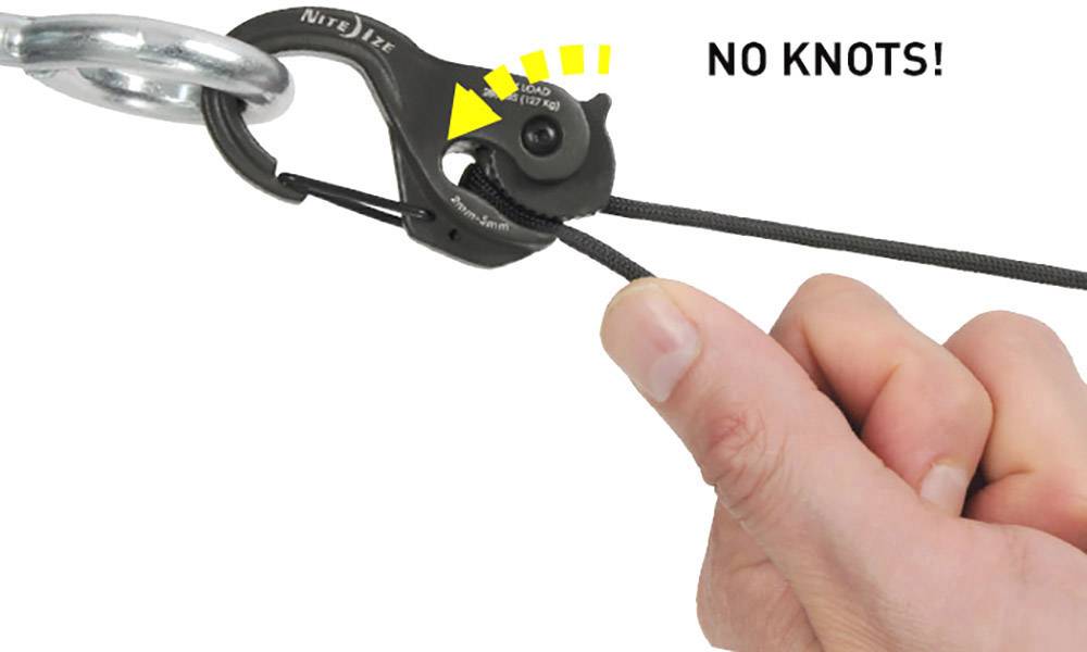 Una mano tira un cavo che passa attraverso un clip nero con la scritta 'NO KNOTS!' per creare un collegamento resistente.