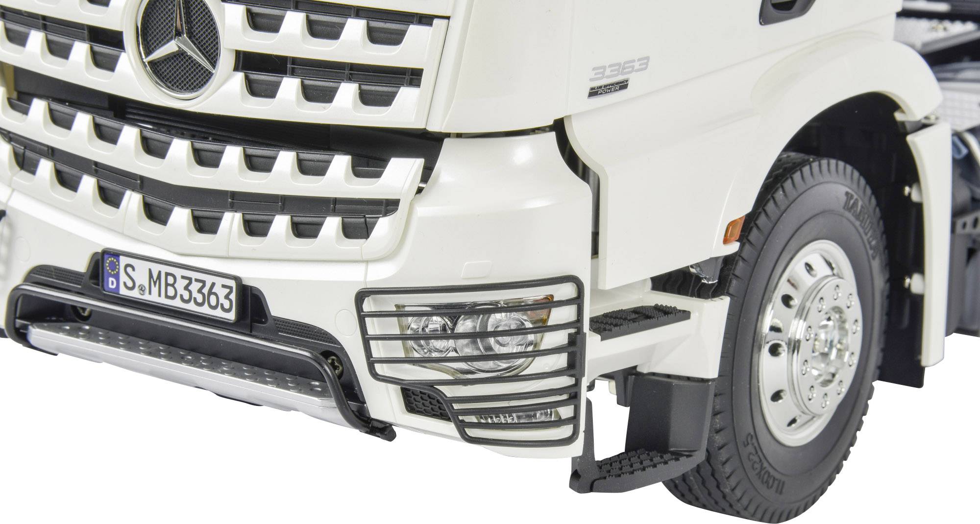 Vista frontale di un camion bianco con logo a stella, griglia del radiatore argento e dettagli dei fari anteriori e della ruota.