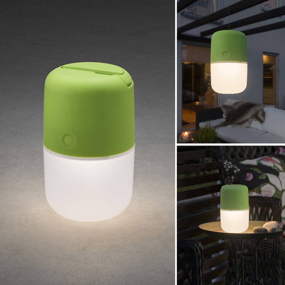 Lampada portatile con parte superiore verde che emana una luce accogliente. Mostrata in ambienti interni ed esterni con un'atmosfera rilassata.