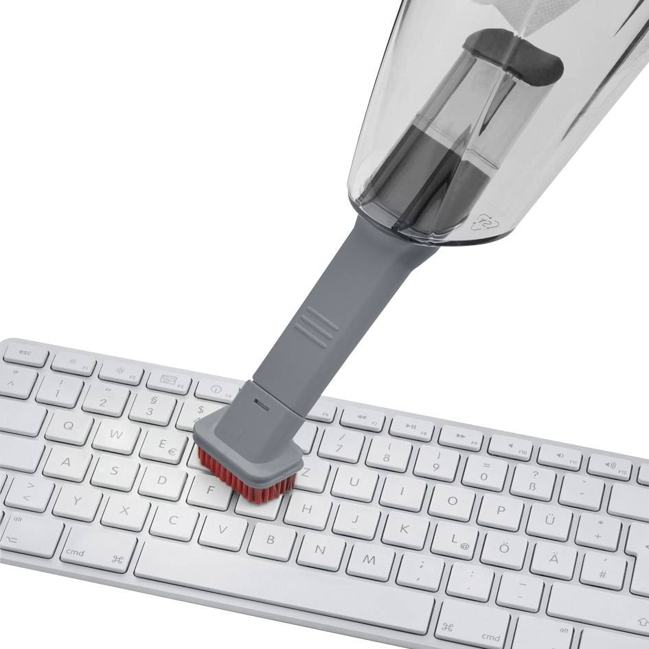 Un piccolo aspirapolvere pulisce gli spazi tra i tasti di una tastiera per computer. L'aspirapolvere ha un apposito accessorio con spazzola.