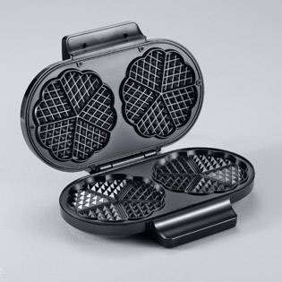 Un ferro per waffle nero con due incavi a forma di cuore su sfondo bianco. L'apparecchio è aperto e pronto per cuocere.