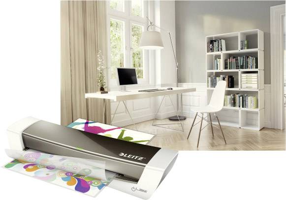 Un posto di lavoro moderno con scrivania, sedia e scaffale. In primo piano un plastificatore che sta plastificando documenti colorati.