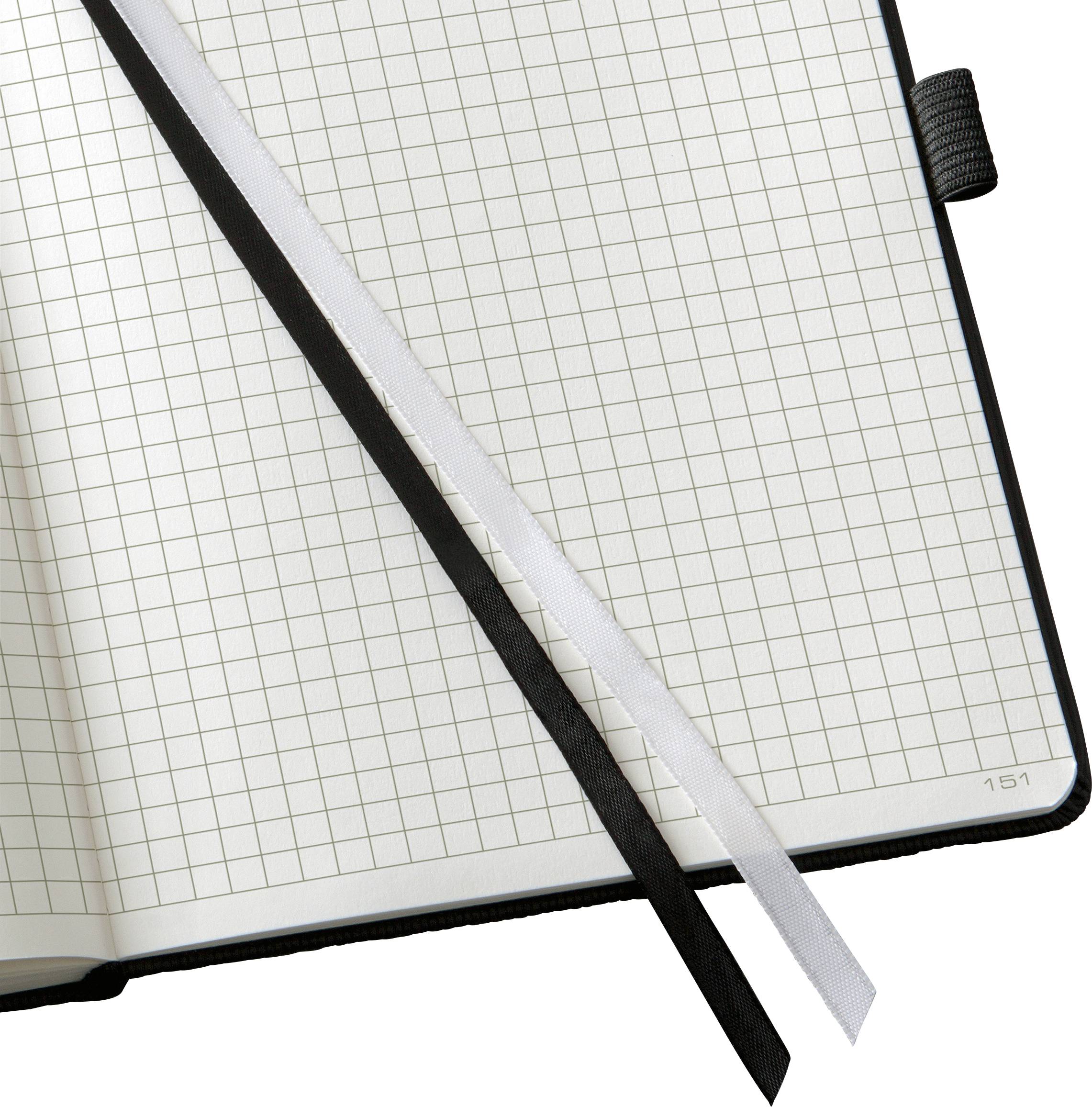 Un taccuino aperto con pagine a quadretti e due segnalibri, uno nero e uno bianco.