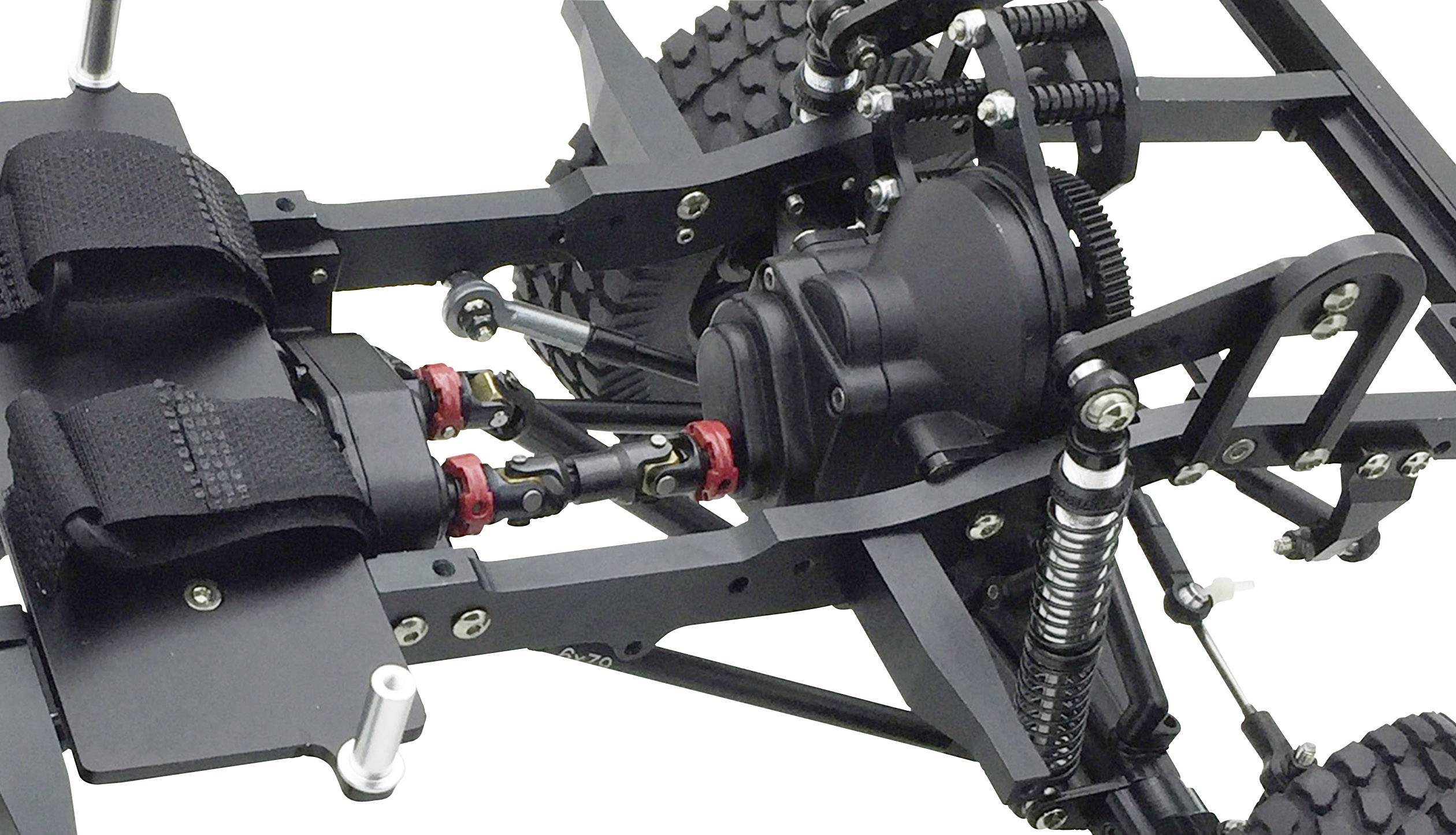 Primo piano di un telaio di un'auto radiocomandata con ammortizzatori e gruppo powertrain, che mostra i dettagli meccanici della struttura del veicolo.