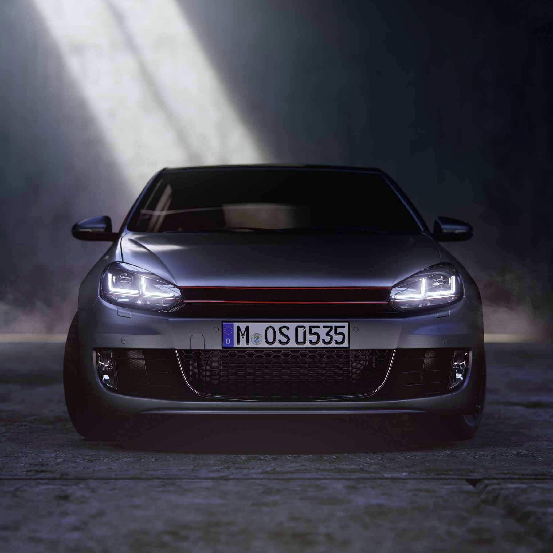Un'auto argentata è parcheggiata in un ambiente scuro, illuminata da un singolo raggio di luce dall'alto. La targa riporta 'M 05535'.