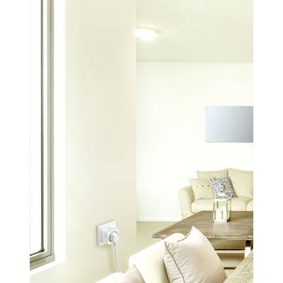 Soggiorno luminoso con divano beige, tavolo in legno e specchio a parete. Un adattatore intelligente per prese è montato nella parete.