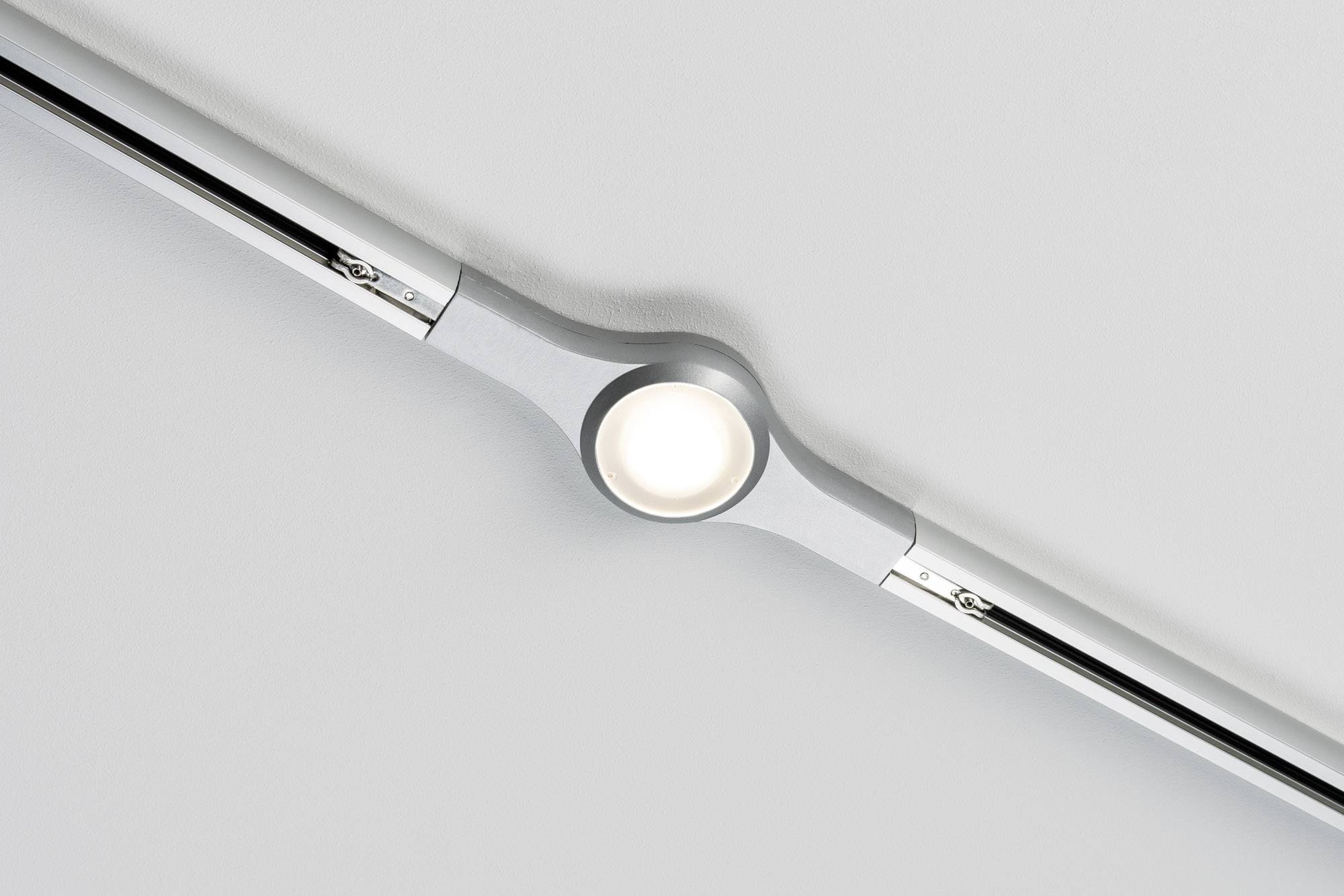 Plafoniera con cornice circolare argentata e faretto LED integrato. Montata su un soffitto bianco.