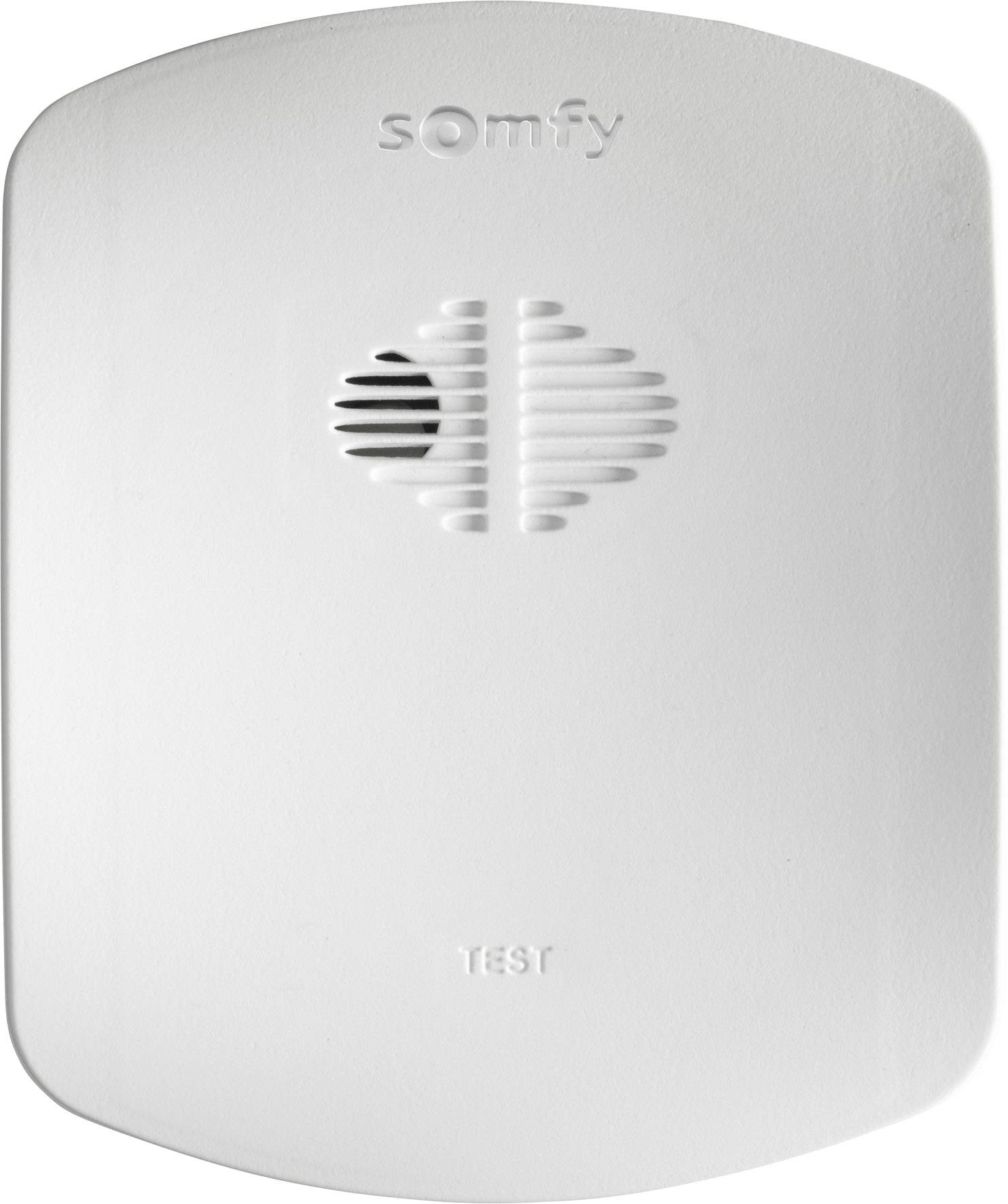 Un rilevatore di fumo bianco con la scritta 'Somfy' in alto e 'Test' in basso. Aperture di ventilazione al centro.