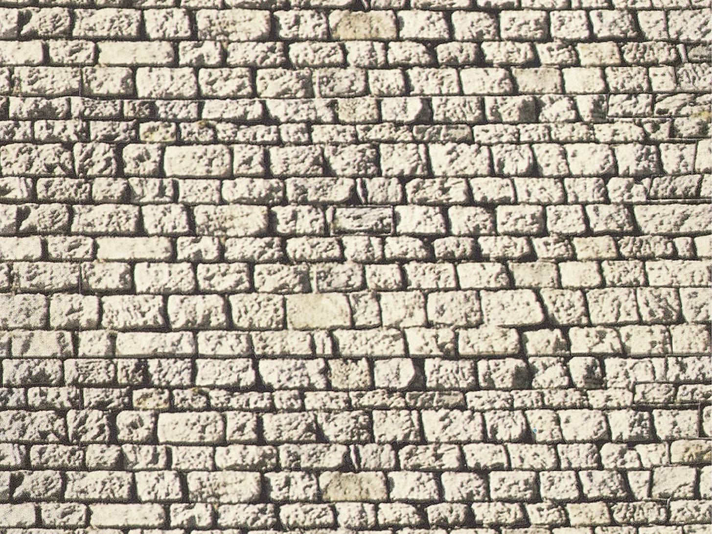 Muro in mattoni con pietre irregolari e chiare di dimensioni diverse. Le fughe sono sottili e scure.