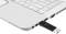 Una chiavetta USB è collegata a un laptop bianco. Il laptop è parzialmente aperto e mostra la tastiera nell'angolo superiore.