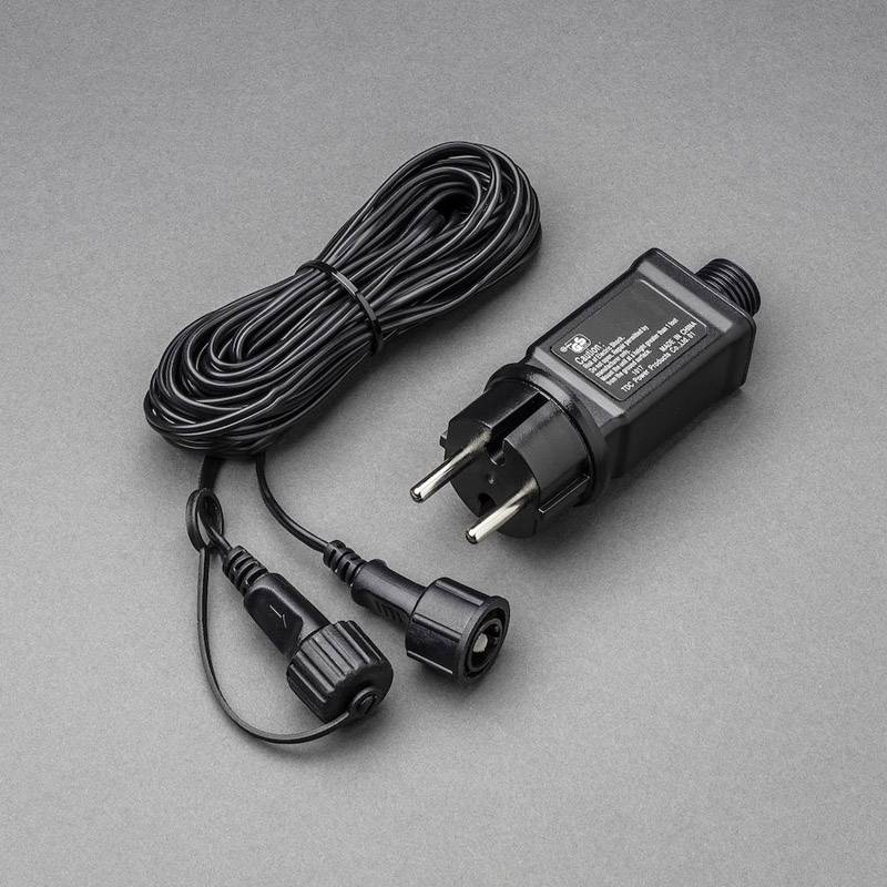 Alimentatore nero con spina europea e cavo su sfondo grigio. Adatto per dispositivi elettrici e fornisce corrente continua.