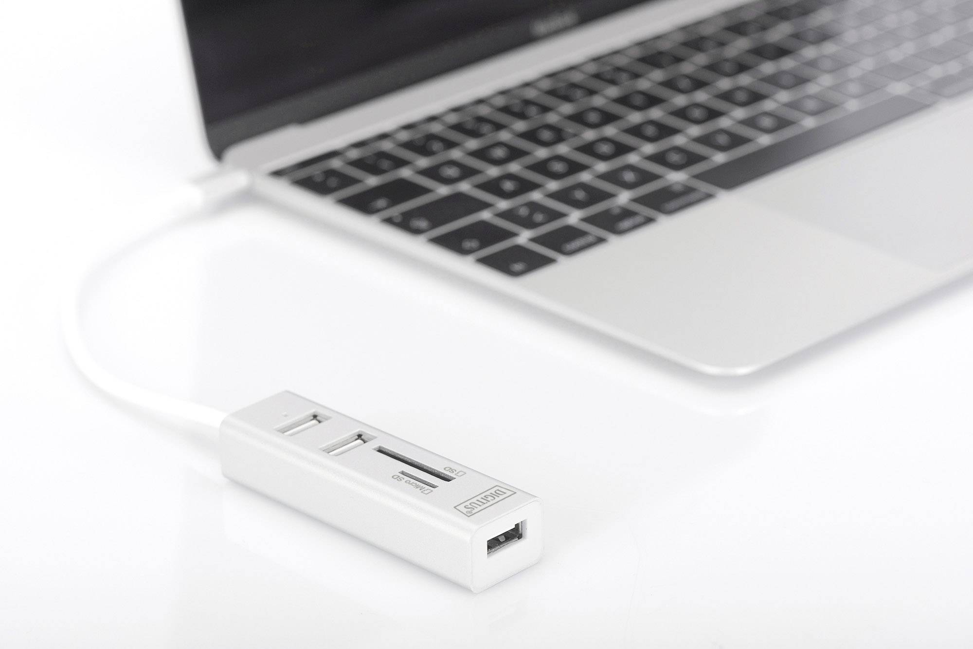 Un laptop con un hub USB bianco collegato, che offre più porte USB e slot per schede.