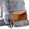 Zaino da trekking grigio con tasca laterale aperta, rivestita internamente di colore arancione, su sfondo chiaro.