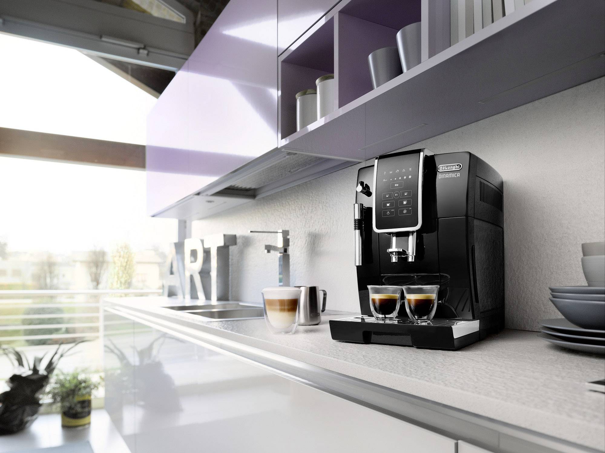 Una macchina da caffè nera su un bancone della cucina sta preparando due espressi. Accanto c'è un latte macchiato e alcune stoviglie.