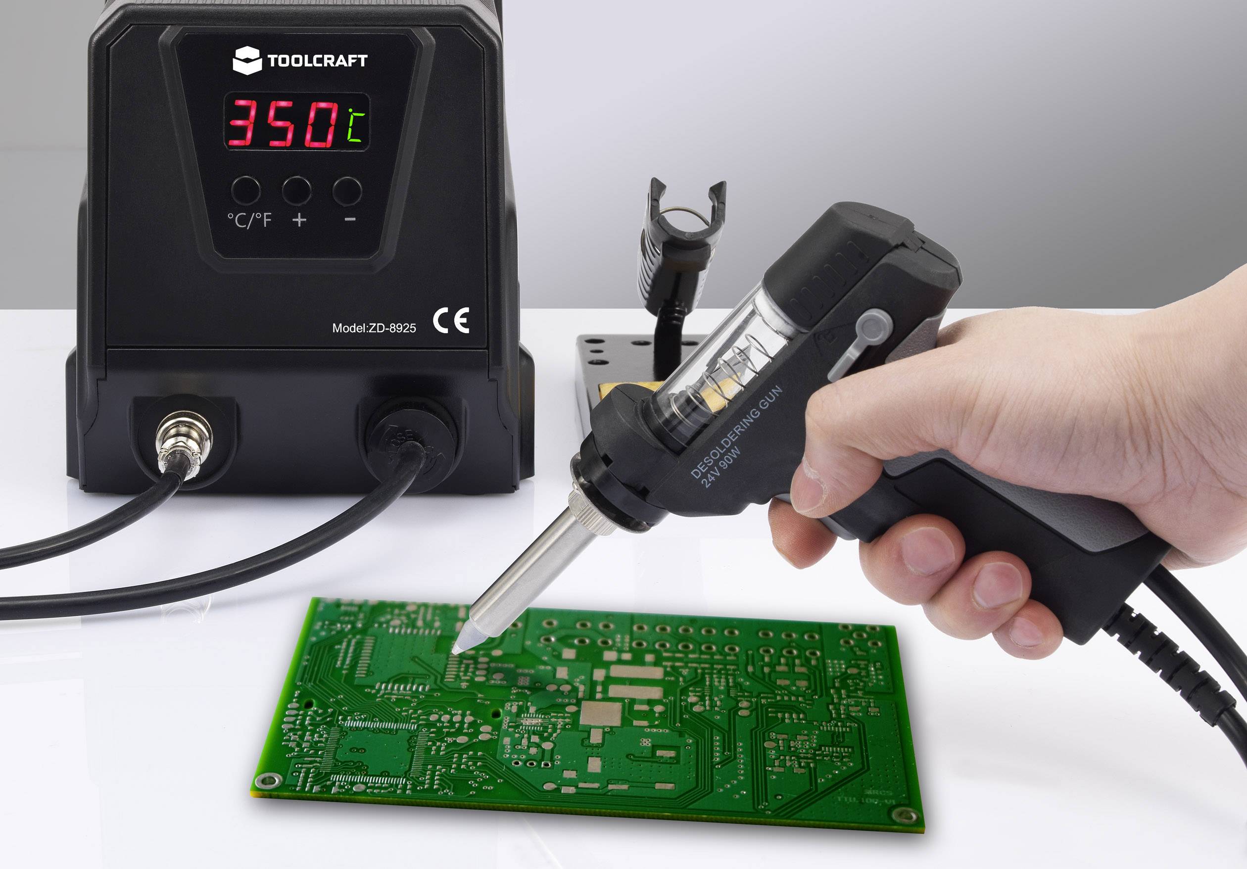 Una mano salda con un saldatore su una scheda elettronica verde. Il saldatore è impostato a 350 gradi Celsius.