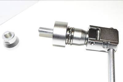 Pezzo di collegamento metallico con filettatura e dado su sfondo bianco; mostra componenti per fissaggio o connessione meccanica.