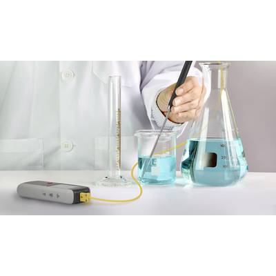 Una persona con camice da laboratorio misura il pH di un liquido blu in un becher utilizzando uno strumento di misurazione.