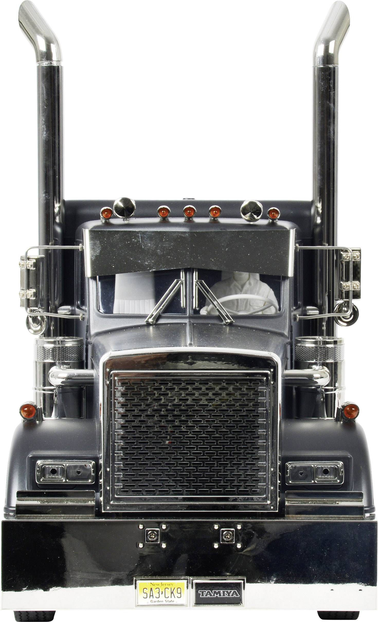 Camion giocattolo nero con grandi tubi di scarico e griglia frontale. Nome del marchio 'Tamiya' visibile sulla targa in basso.