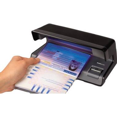 Un dispositivo di scansione sta eseguendo la scansione di un documento di viaggio con lampada UV integrata. Una mano tiene il documento durante il processo di scansione.