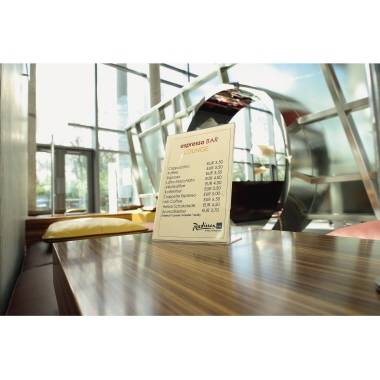 Menù poggiato su un tavolo in un lounge moderno, che mostra i prezzi di varie specialità caffetterie, con finestre sullo sfondo.