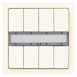 Un interruttore beige con sei tasti e una cornice grigia al centro, probabilmente utilizzato per controllare diverse fonti luminose.