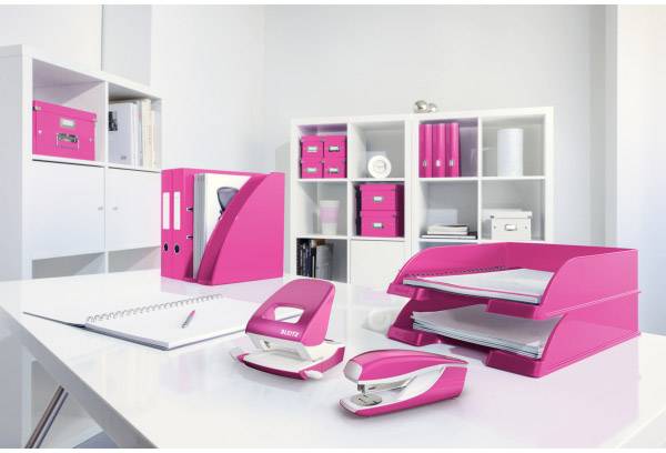 Ufficio moderno arredato con mobili bianchi, articoli in rosa come cartelle e raccoglitori, notebook sul tavolo.