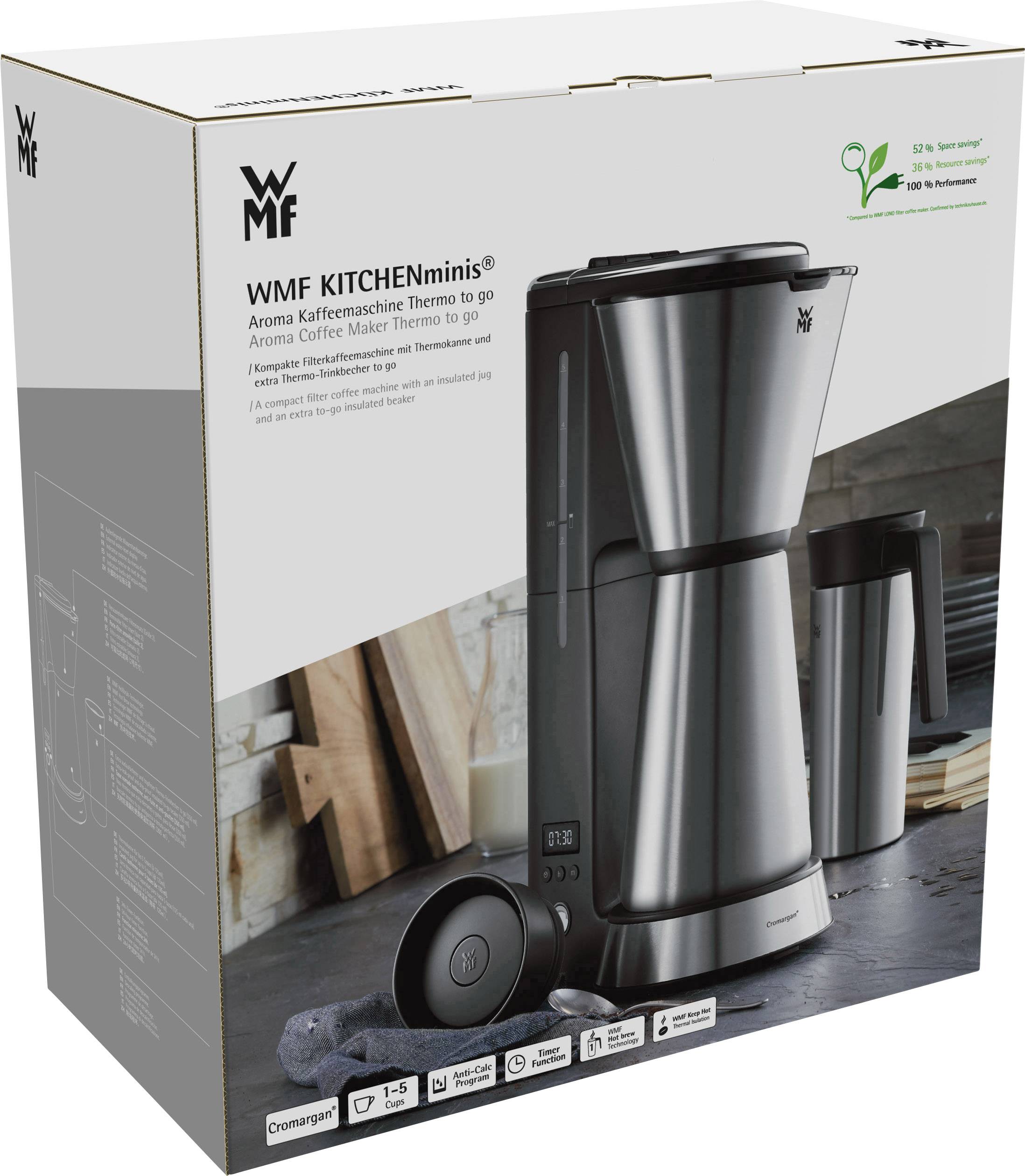 Macchina da caffè con caraffa termica e macinacaffè su sfondo grigio. La confezione mostra il nome del marchio 'WMF KITCHENminis' e i dettagli del prodotto.