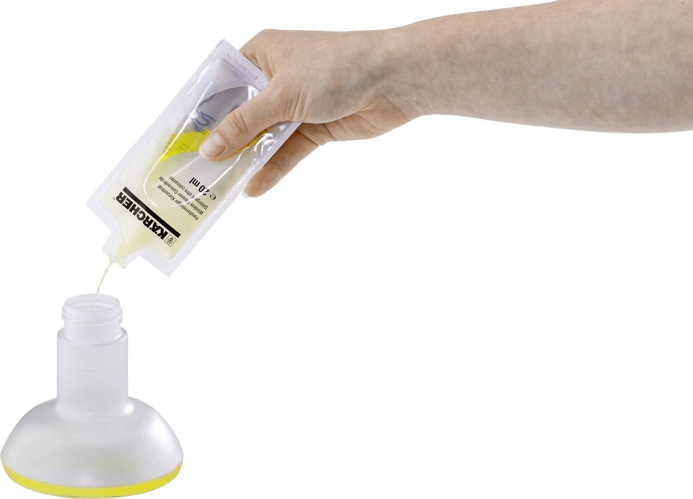 Una mano versa un liquido giallo da una sacca in un contenitore rotondo.