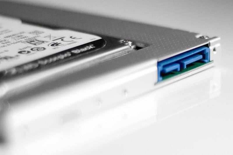 Primo piano di un collegamento per hard disk esterno con uno slot blu su un involucro argentato.