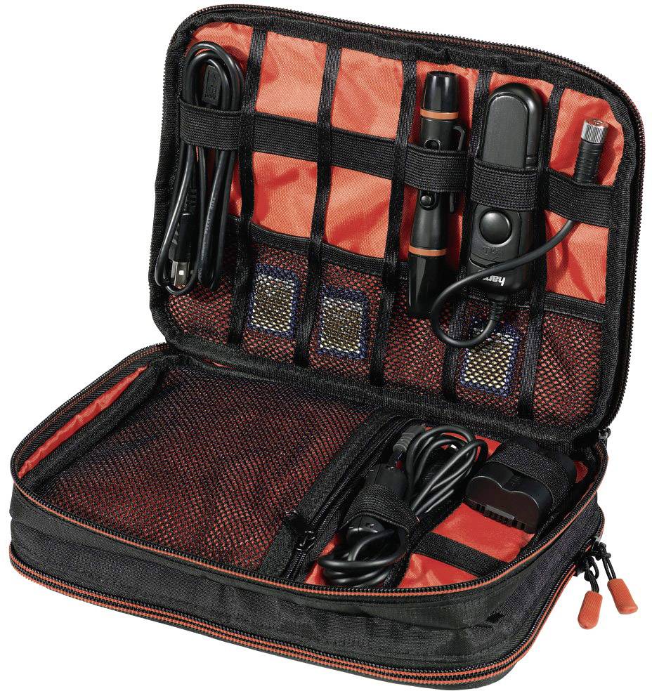 'Borsa nera aperta con accenti rossi, riempita con diversi cavi e accessori elettronici organizzati in tasche a rete.'