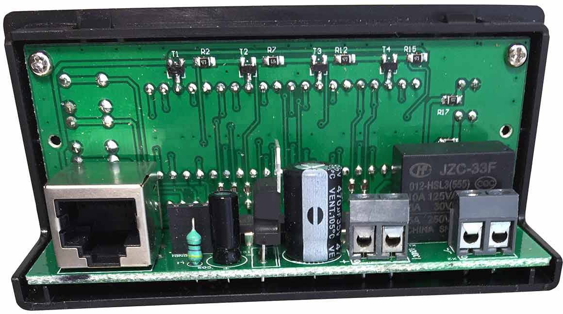 'Primo piano di un circuito elettronico verde con diversi componenti, tra cui un relè, un connettore RJ45 e condensatori.'