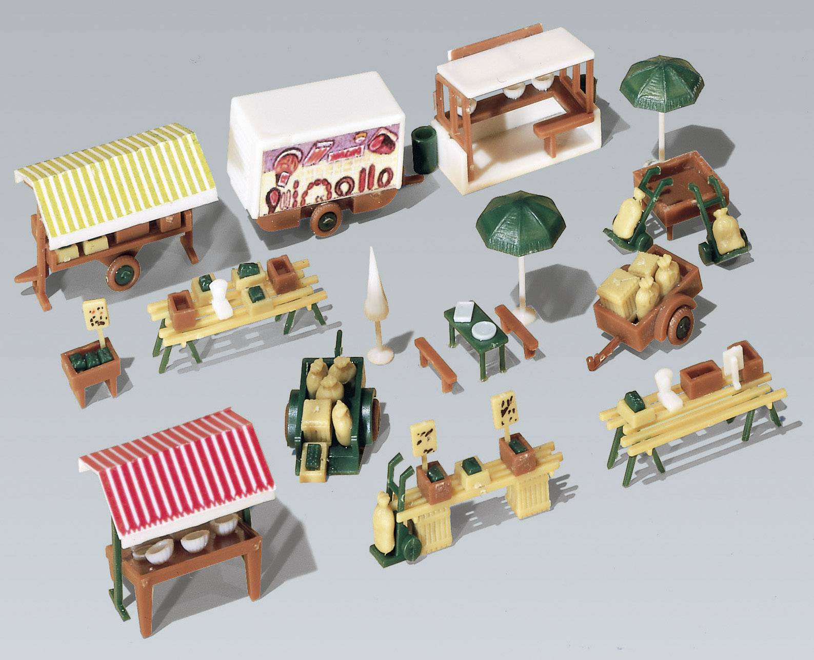 Diversi piccoli chioschi e stand in formato miniatura, tra cui bancarelle di mercato con tende da sole, tavoli con cibi e ombrelloni decorativi.