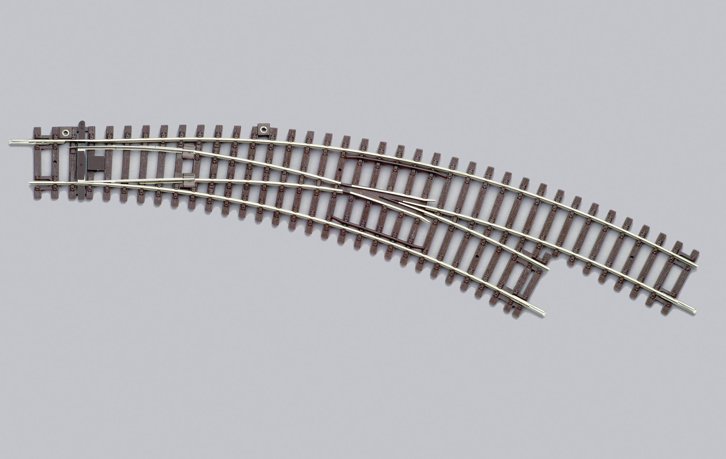 Pezzo di binario ferroviario con un deviatoio che mostra una curva e due possibili direzioni, diritto a sinistra, deviazione a destra.