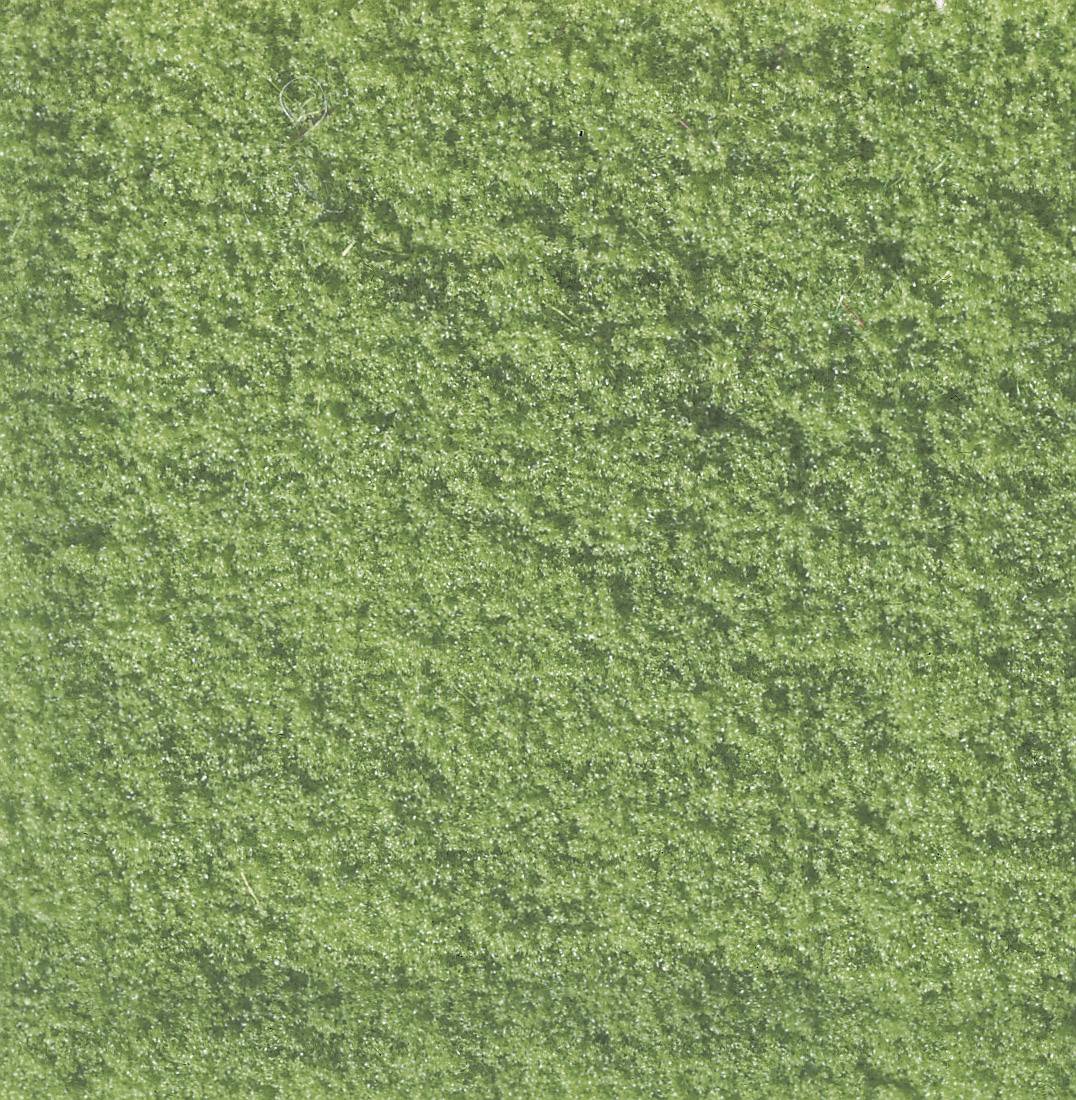 Un primo piano di erba sintetica verde, uniformemente strutturata.
