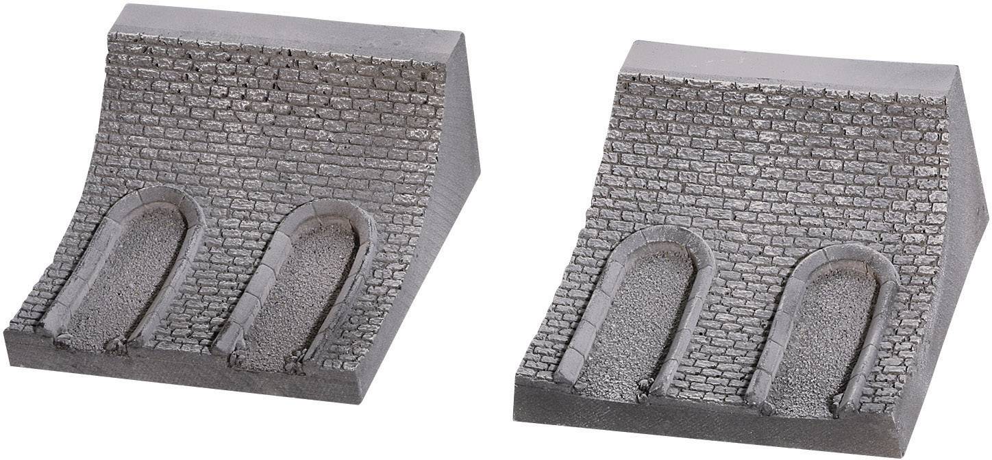 Due ponti ferroviari in miniatura affiancati, realizzati con un'imitazione di pietra, ciascuno con due aperture di tunnel, circondati da una struttura rocciosa dall'aspetto realistico.