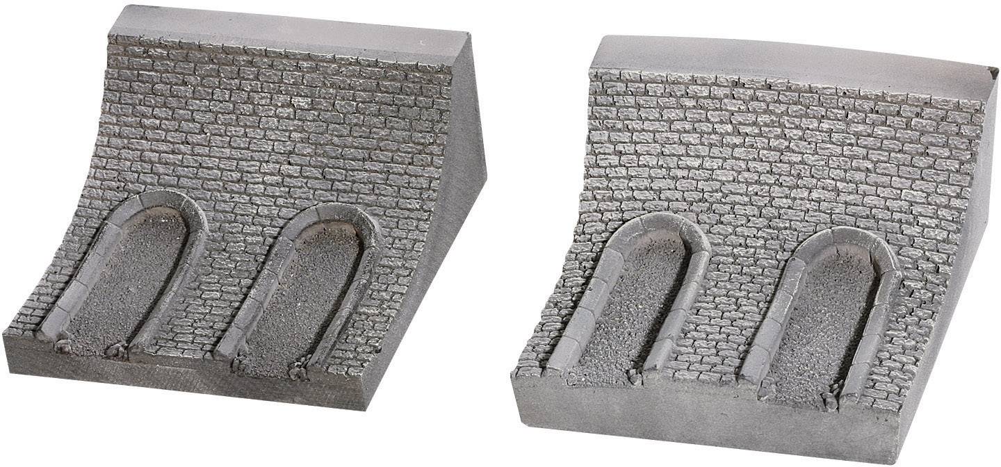 Due pezzi di muro curvi di colore grigio, ciascuno con due aperture ad arco di tunnel. Sono realizzati in un materiale simile alla pietra.
