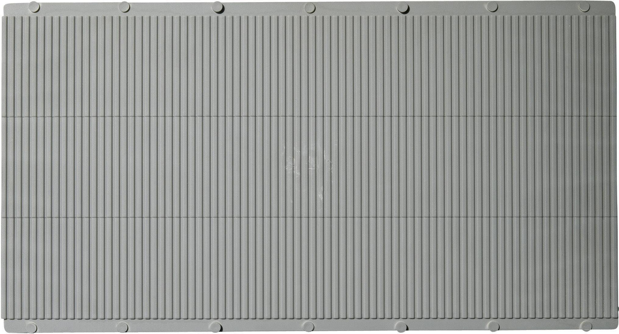 Vista di un oggetto rettangolare grigio con linee verticali, probabilmente parte di un dispositivo tecnico o di una macchina.