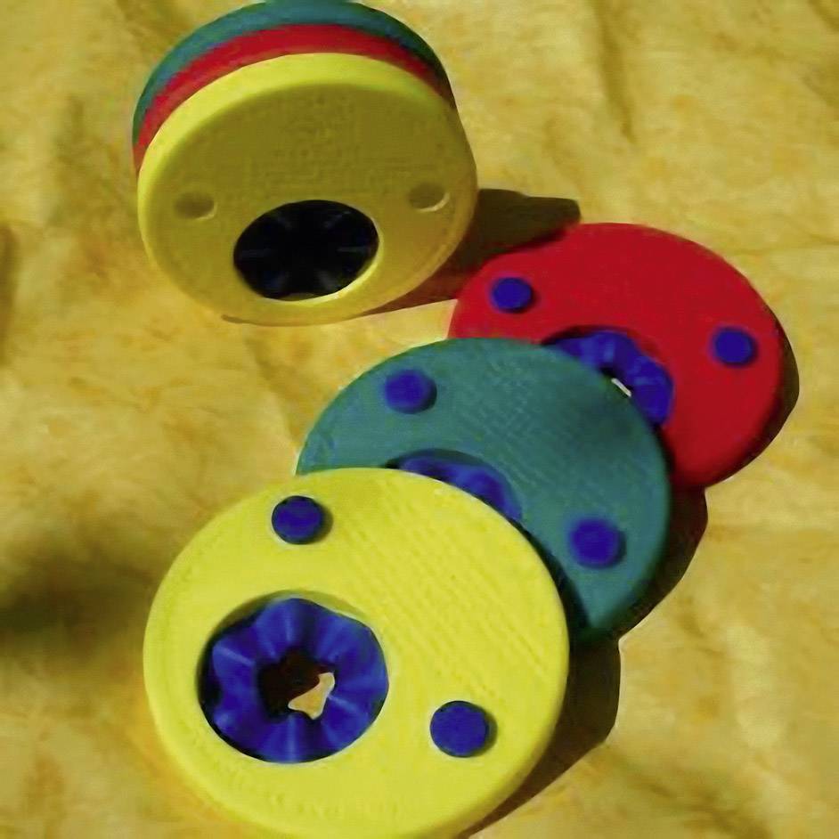 Tre taglierine colorate con cerchi multicolori impilate l'una sull'altra su uno sfondo giallo.
